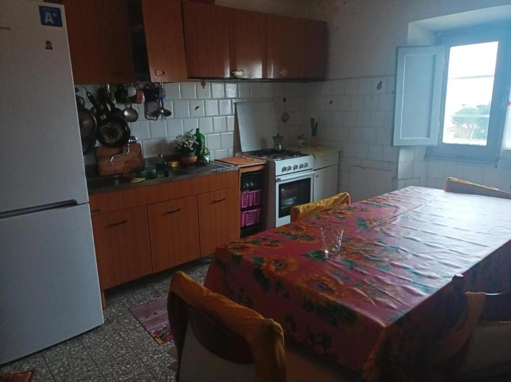 een keuken met een tafel en een tafel en een koelkast bij Palm Tree Room 1 in Prato
