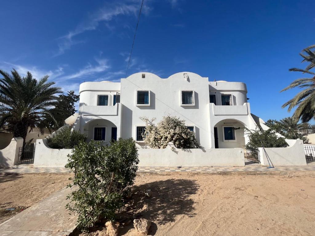 a white house with a tree in front of it at App 2 chambres rdc 200m de la plage in Mezraya