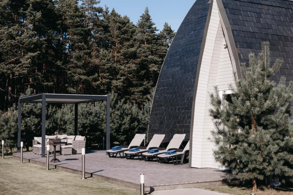 a group of lounge chairs and a gazebo at CIPRESES in Engure