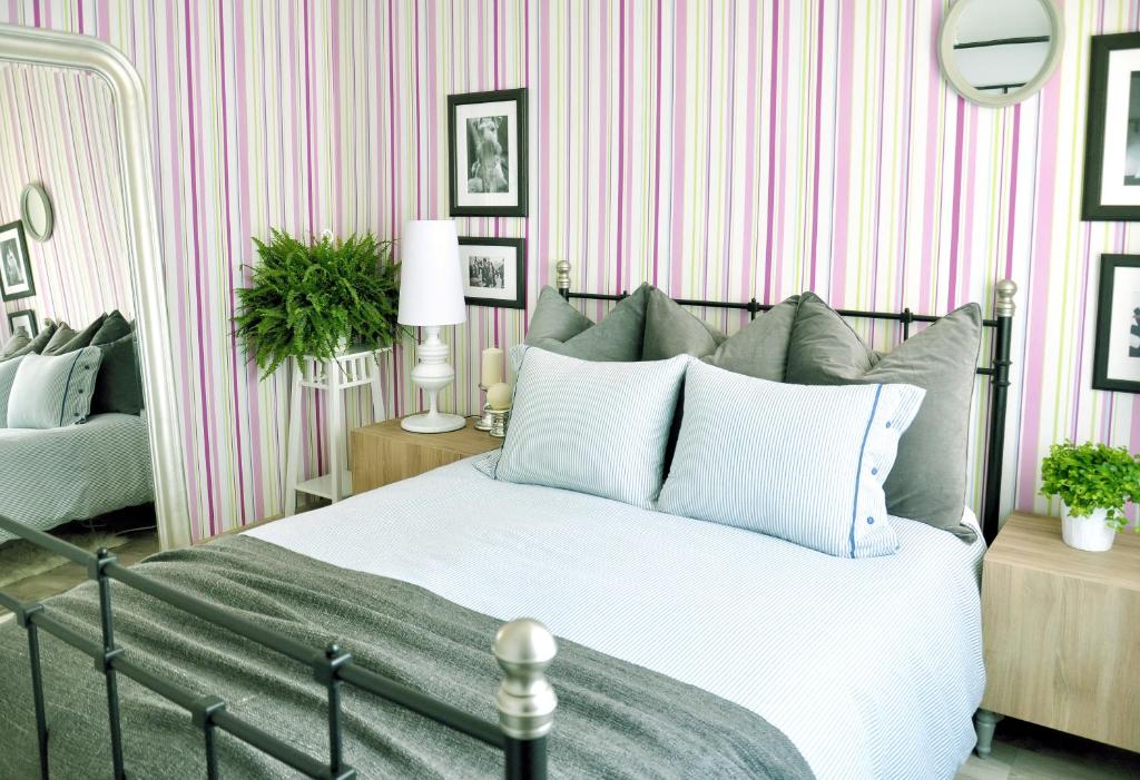 um quarto com uma cama e riscas cor-de-rosa e brancas em Chic & Cheap em Barcelona