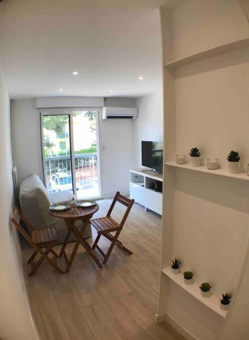 un salon avec une table et des chaises et une cuisine dans l'établissement Nice bas Cimiez- Coquet F1, climatisée, Parking, à Nice