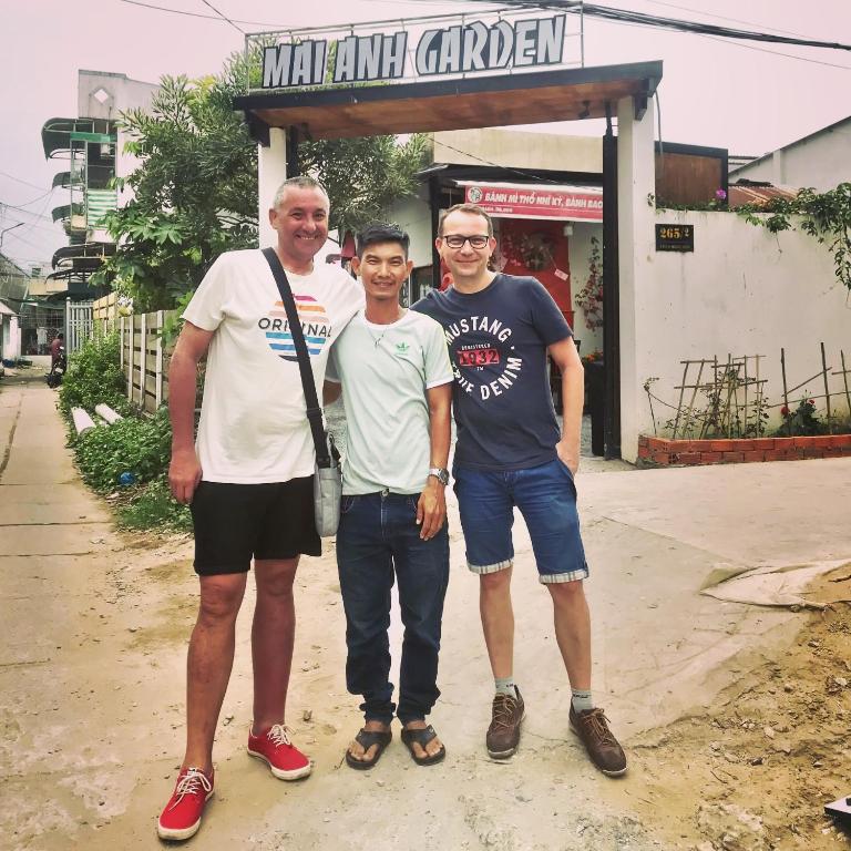 un grupo de tres hombres parados frente a una tienda en Mai Anh Garden, en Soc Trang