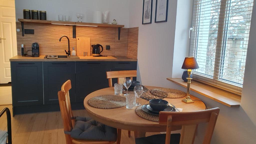 eine Küche mit einem Holztisch mit Stühlen und einem Esszimmer in der Unterkunft Apartament Wieżyczka in Świdnica
