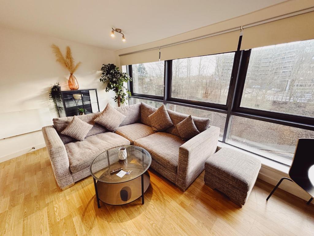 a living room with a couch and a glass table at 2 Bed Apartment Sleeps 6 Modern Secure Parking + Lift in Newcastle upon Tyne