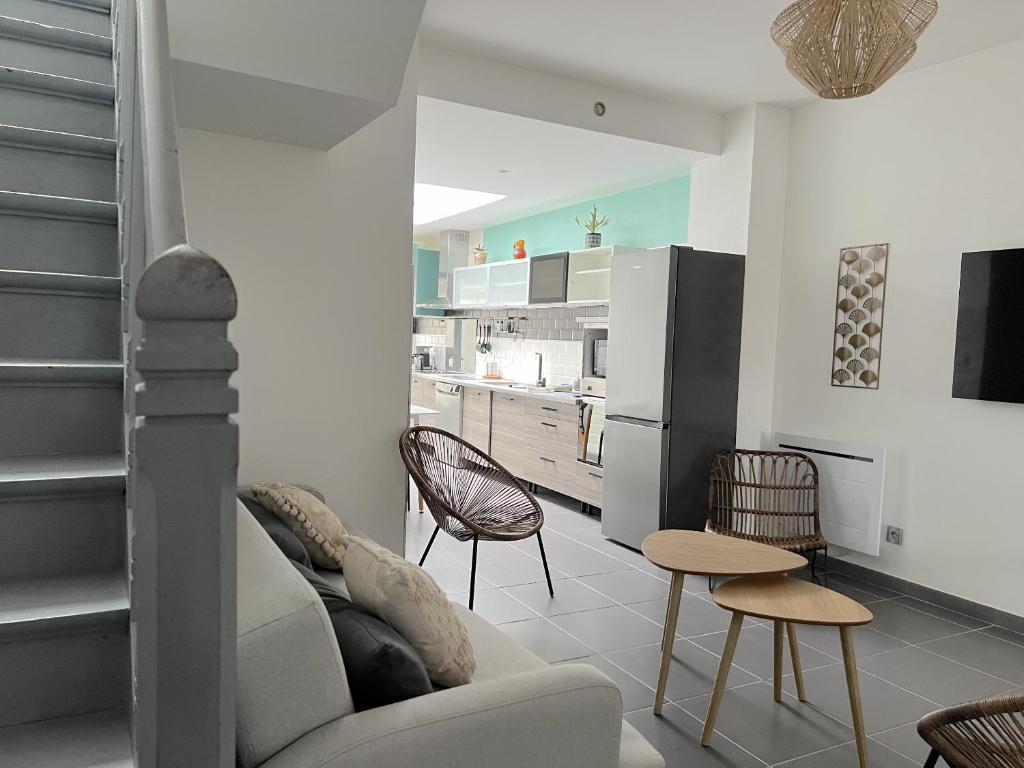 een woonkamer met een bank en een keuken bij Maison 5 chambres proche toutes commodités in Roubaix