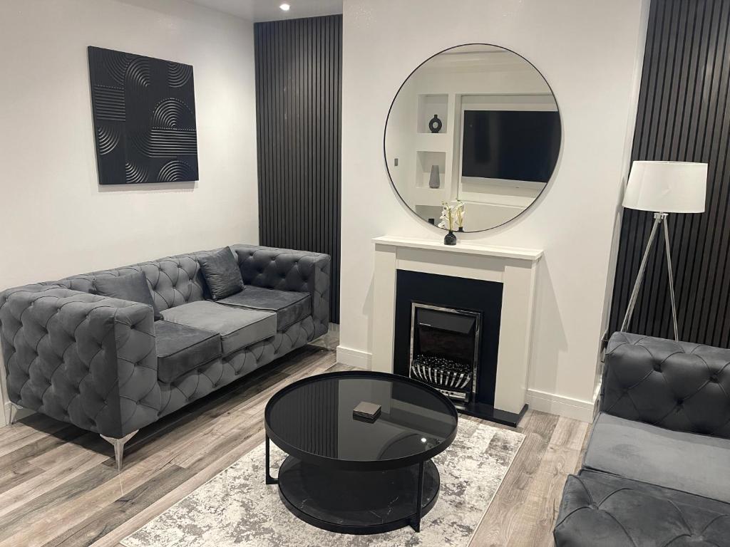 uma sala de estar com um sofá e um espelho em DULEX ROOMS em Scunthorpe
