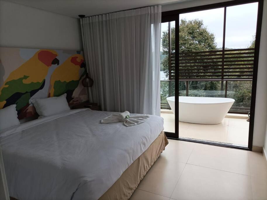 1 dormitorio con 1 cama grande y bañera en Apartamento no Capivai Eco Resort Residence en Represa Capivari