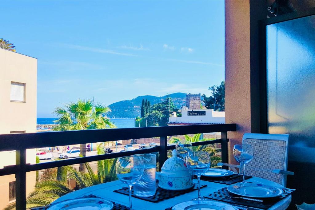 - une table avec des verres à vin sur un balcon avec vue dans l'établissement Somptueux deux pieces, entre mer & piscine !, à Mandelieu-la-Napoule