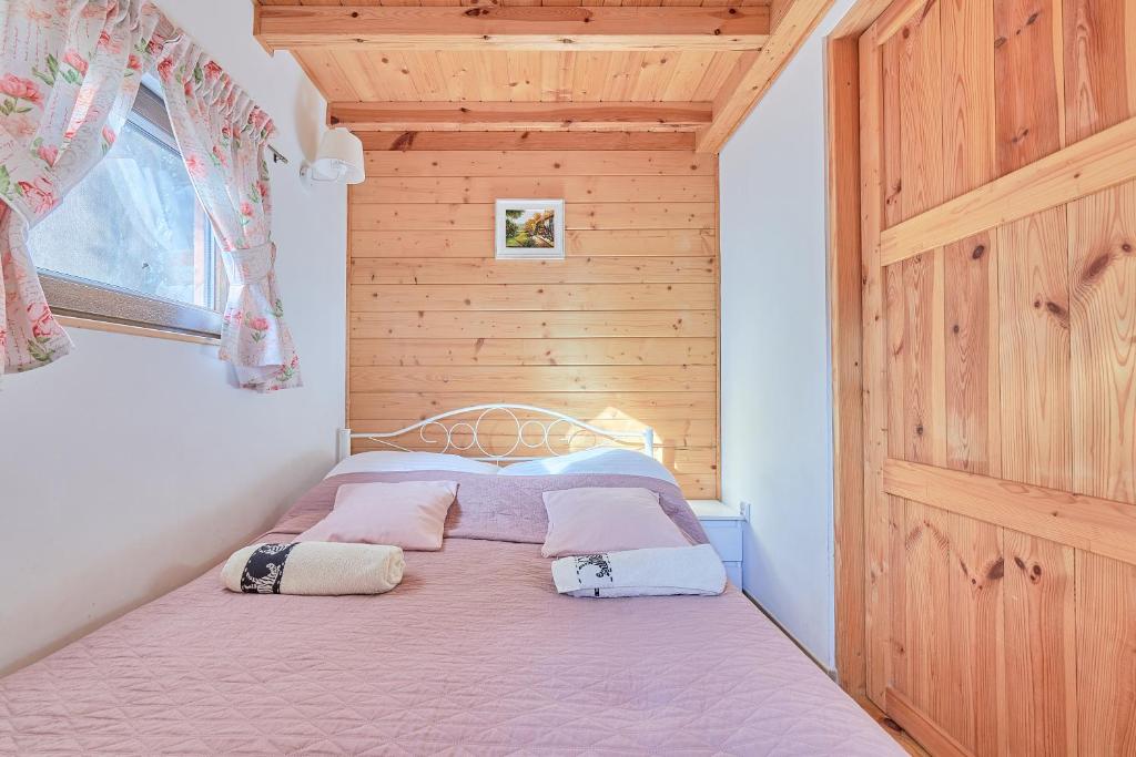 1 dormitorio con 1 cama con 2 almohadas en Agroturystyka Barycz Całoroczny Domek Marcel, en Końskie