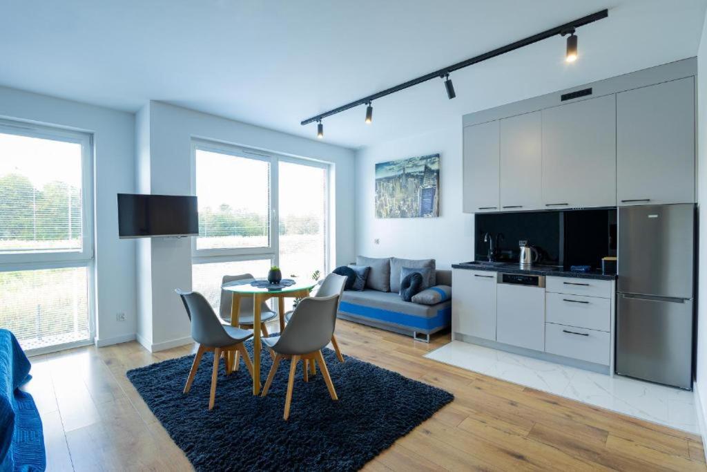 a kitchen and living room with a table and chairs at Lux Apartment in Rzeszów