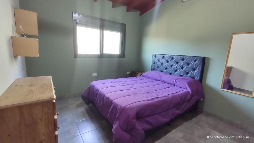- un lit violet dans une chambre avec fenêtre dans l'établissement Hermosa casa en barrio la toma, à Capilla del Monte