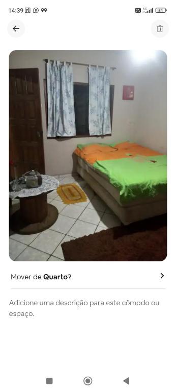 a picture of a bedroom with a bed and a table at Suíte independente a 10 minutos da praia in Vila Velha