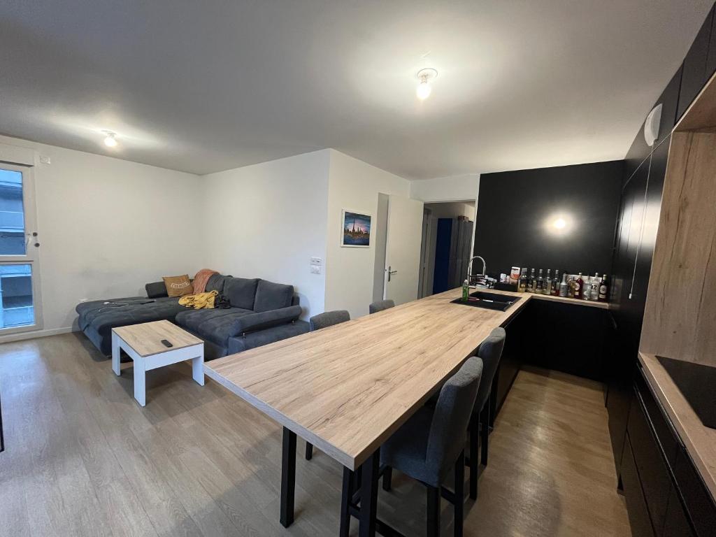 une cuisine et un salon avec une table et un canapé dans l'établissement Spacious apartment with big terrace - close to Paris, à Villeneuve-la-Garenne