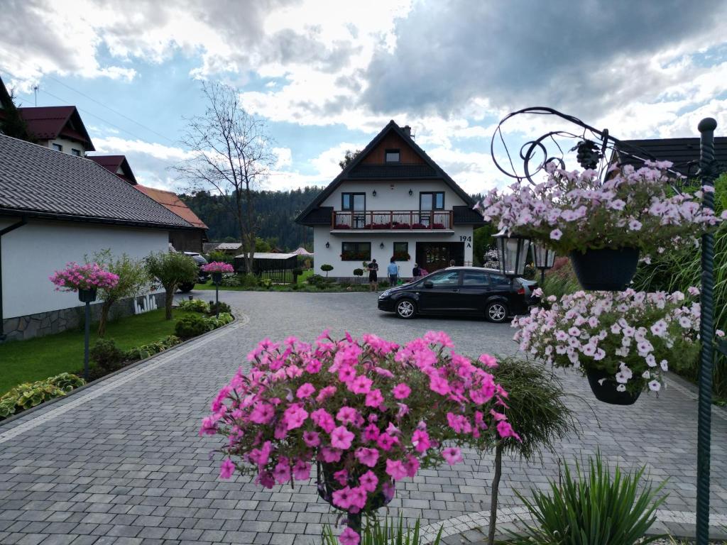 a parking lot with flowers in front of a building at Domek pod Tatrami Jurgów noclegi in Jurgów