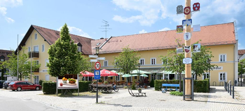 a large yellow building with tables and chairs on a street at Hotel zum Alten Wirt in Langenbach