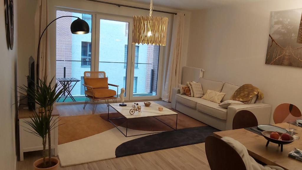 ein Wohnzimmer mit einem Sofa und einem Tisch in der Unterkunft Courbevoie lodge in Louvain-la-Neuve