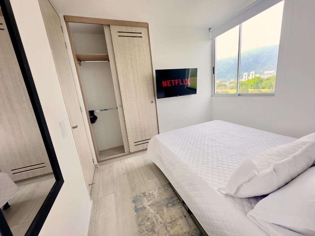 a small bedroom with a bed and a window at Habitación premium sede 3 in Ibagué