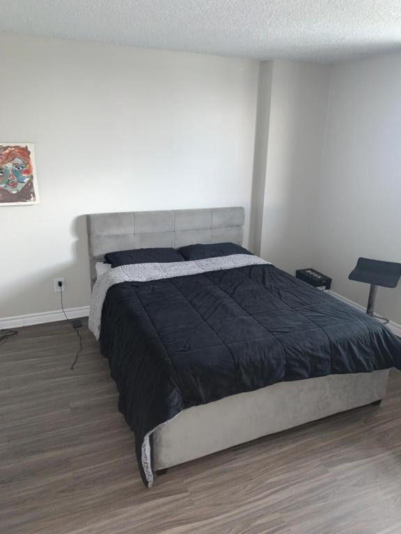 a bedroom with a large bed in a white room at Appartement 2 Chambre neuf in Longueuil