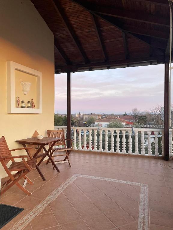 un patio con tavolo e sedie e un balcone. di Athina's House a Xánthi