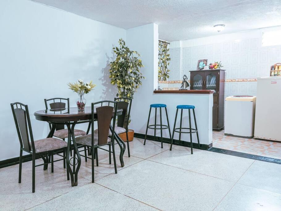 a kitchen with a table and chairs and a refrigerator at Lindo apto amoblado ¡super central! RNT734 in Armenia