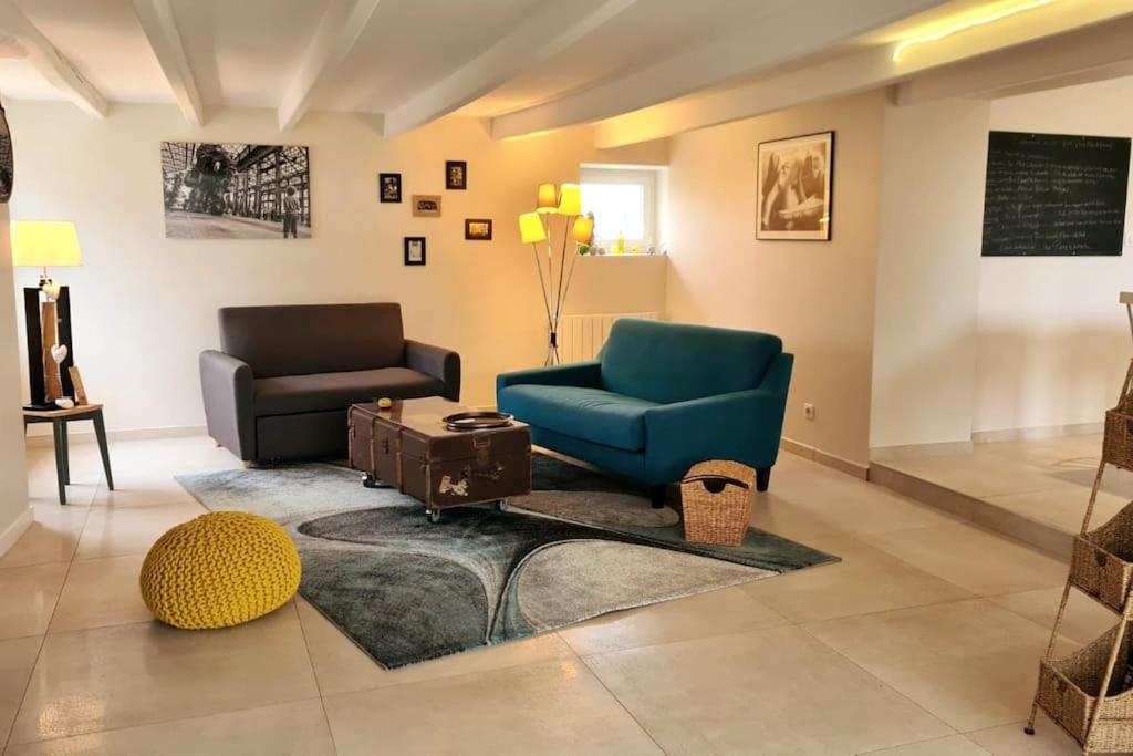 - un salon avec un fauteuil bleu et un canapé dans l'établissement Gîte de charme 3 étoiles à proximité de la mer, à Saint-Molf