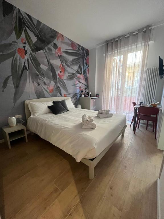1 dormitorio con 1 cama con pared de flores en CALARI ROOMS - AFFITTACAMERE, en Bolonia