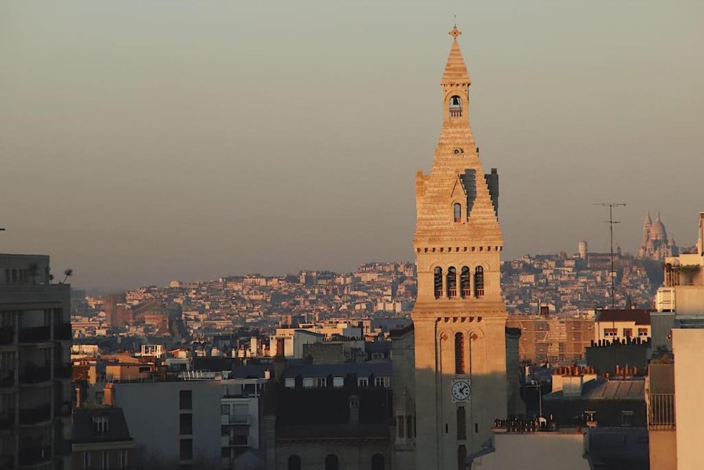 a tall clock tower with a city in the background at Paris Skyview - Latin Quarter & Eiffel Tower in Paris