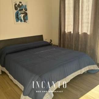 ein Schlafzimmer mit einem Bett mit einer blauen Decke in der Unterkunft Incanto in Paestum