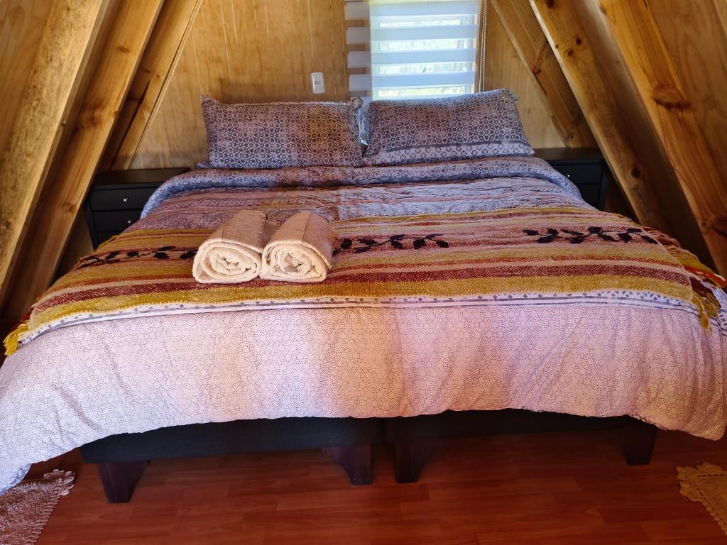 a bed in a room with two towels on it at Travesía Rukamanque Lodge in Temuco