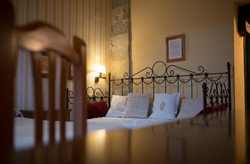 a bedroom with a bed with white pillows at El Lagar del Vero in Huerta de Vero