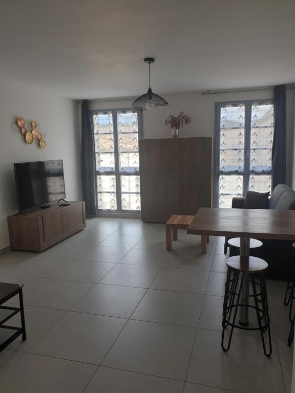 un salon avec une table et une télévision dans l'établissement Appartement à deux pas du port de Bonifacio, à Bonifacio