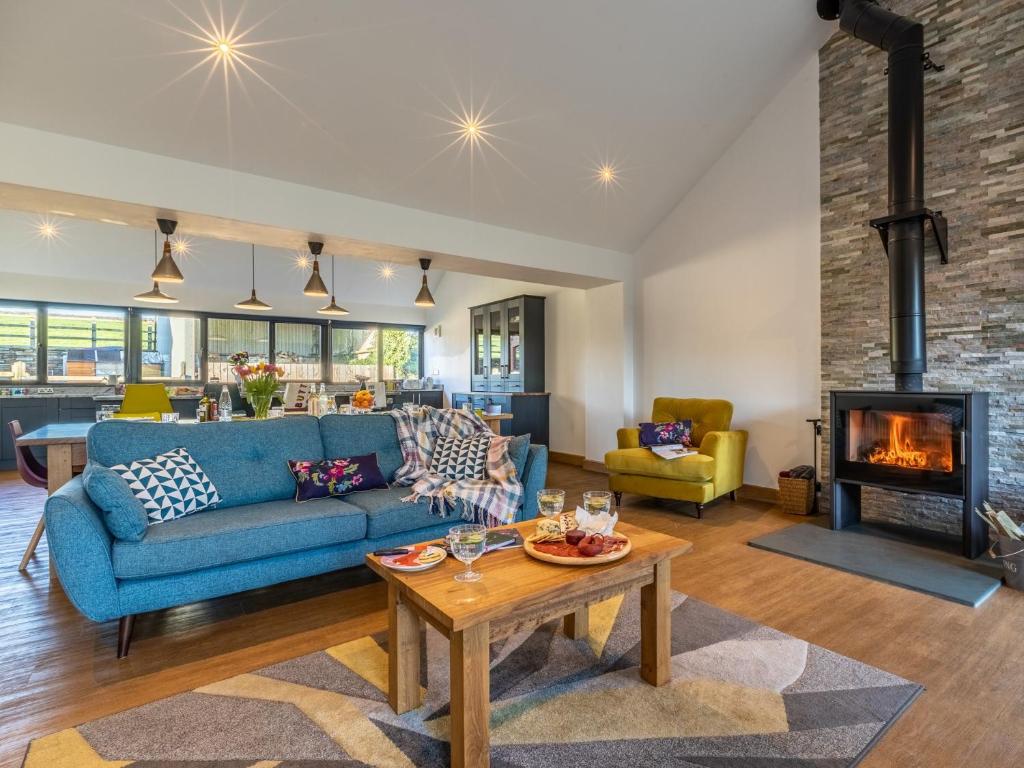 uma sala de estar com um sofá azul e uma lareira em 5 Bed in Widemouth Bay 60490 em Clawton