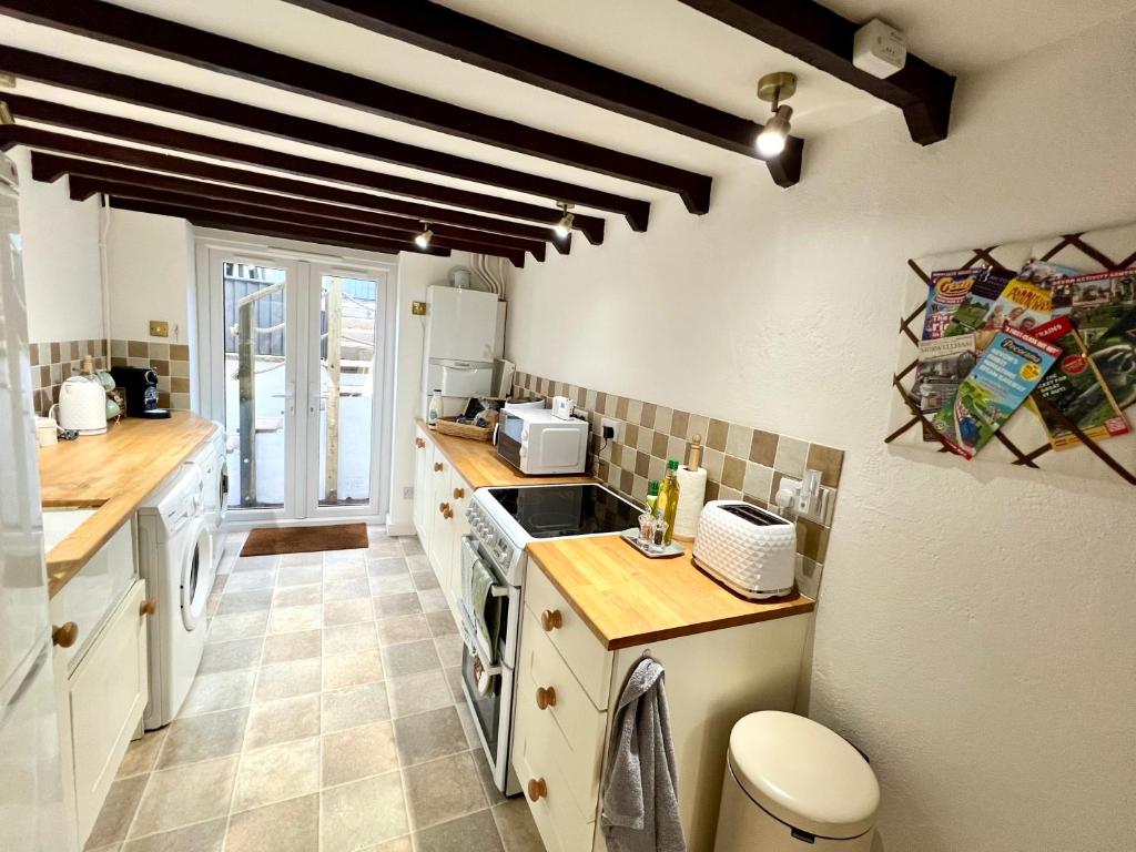 a kitchen with a sink and a stove top oven at Angel Cottage in Bishopsteignton