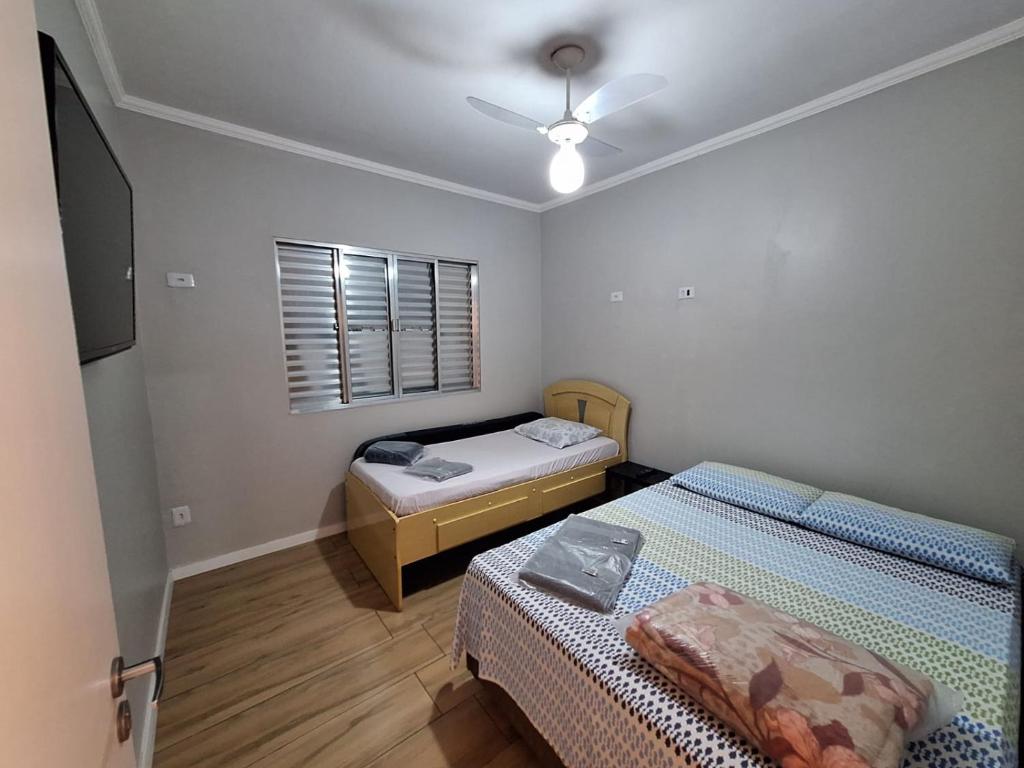sypialnia z 2 łóżkami i wentylatorem sufitowym w obiekcie Hostel My House quartos perto do aeroporto de Guarulhos w mieście Guarulhos