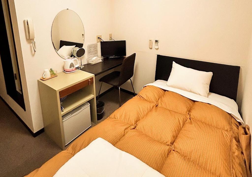 um quarto com uma cama e uma secretária com um espelho em Hotel MitsuWakan - Vacation STAY 87402v em Tsushima
