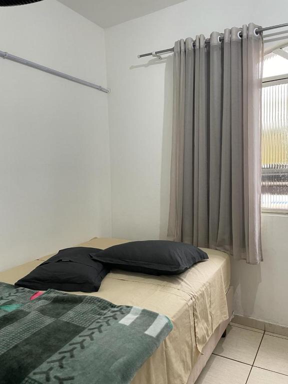 1 dormitorio con cama y ventana con cortina en Hotel Boa Vista, en Matipó