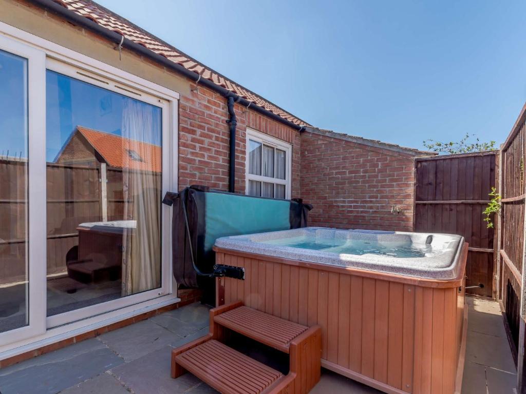 een hot tub op een patio met een stoel bij 3 Bed in Thirsk 40351 in Carthorpe