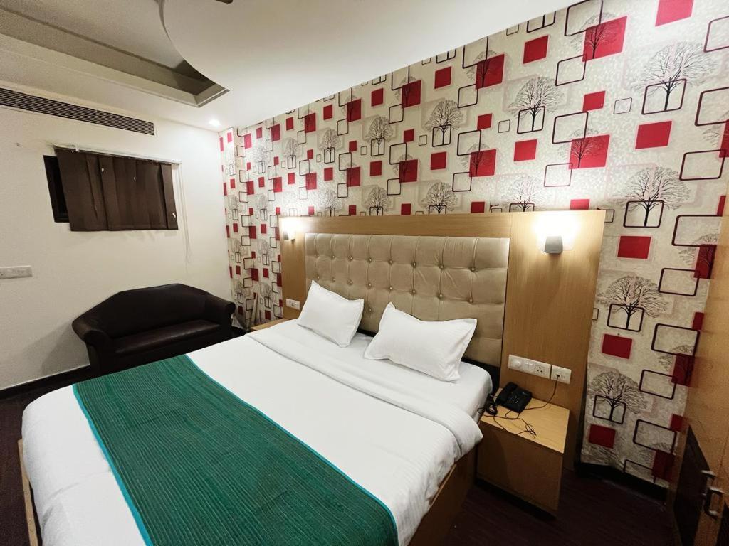Un dormitorio con una cama grande y una pared con cuadros. en Hotel Diamond Airport en Nueva Delhi