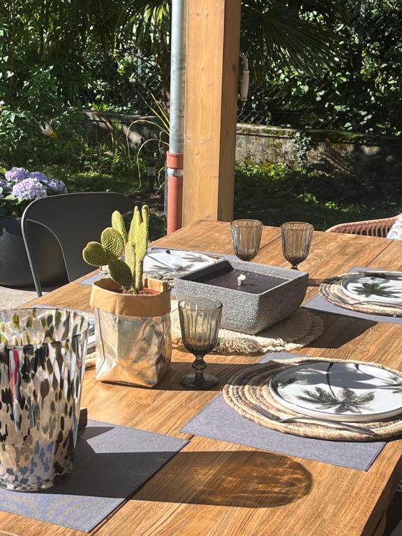 una mesa de madera con platos y vasos encima en Villa Marie en Sévrier