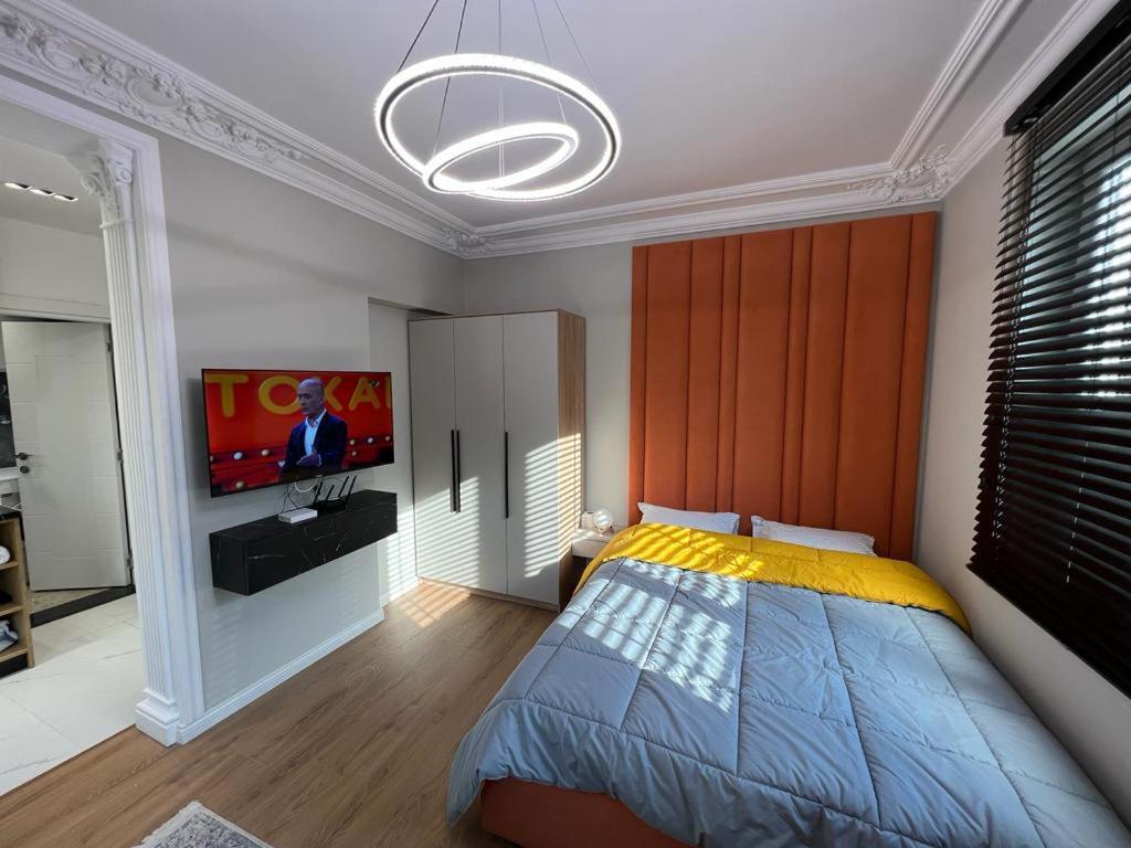 um quarto com uma cama e uma televisão de ecrã plano em Leti Apartments M.Shyri2 em Tirana