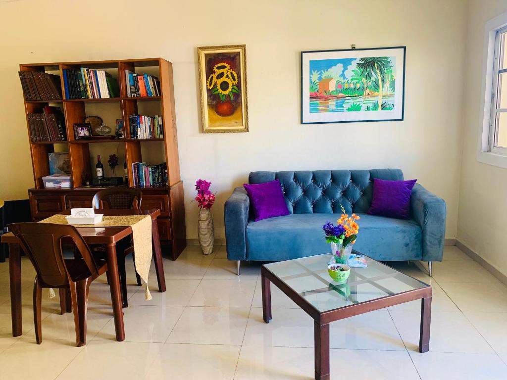 sala de estar con sofá azul y mesa en Habitación cerca del Mar, Obelisco Macho y Zona Colonial, en Santo Domingo