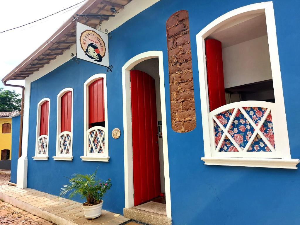 um edifício azul com portas e janelas vermelhas em Pouso da Trilha Hospedagem em Lençóis