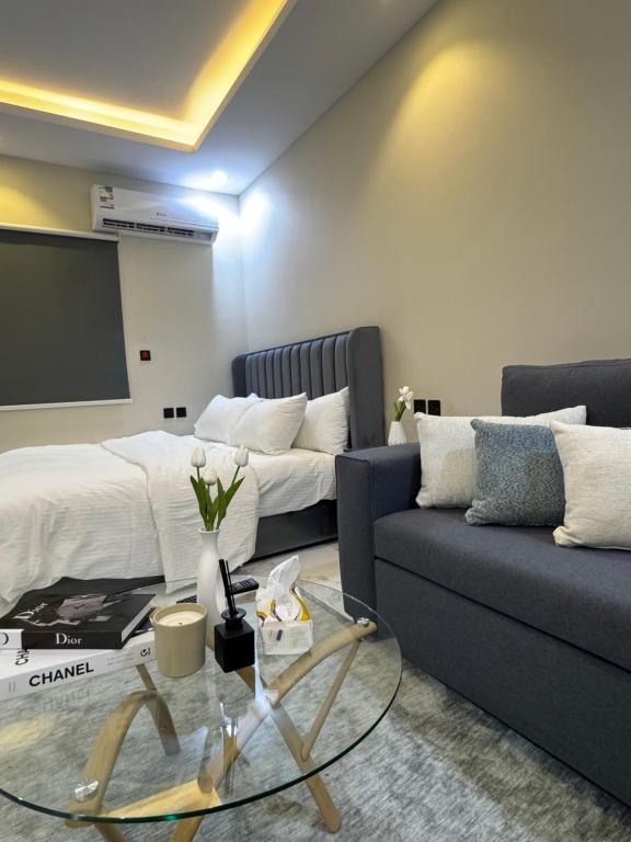 uma sala de estar com um sofá e uma televisão em استديو مميز بدخول ذاتي em Riade