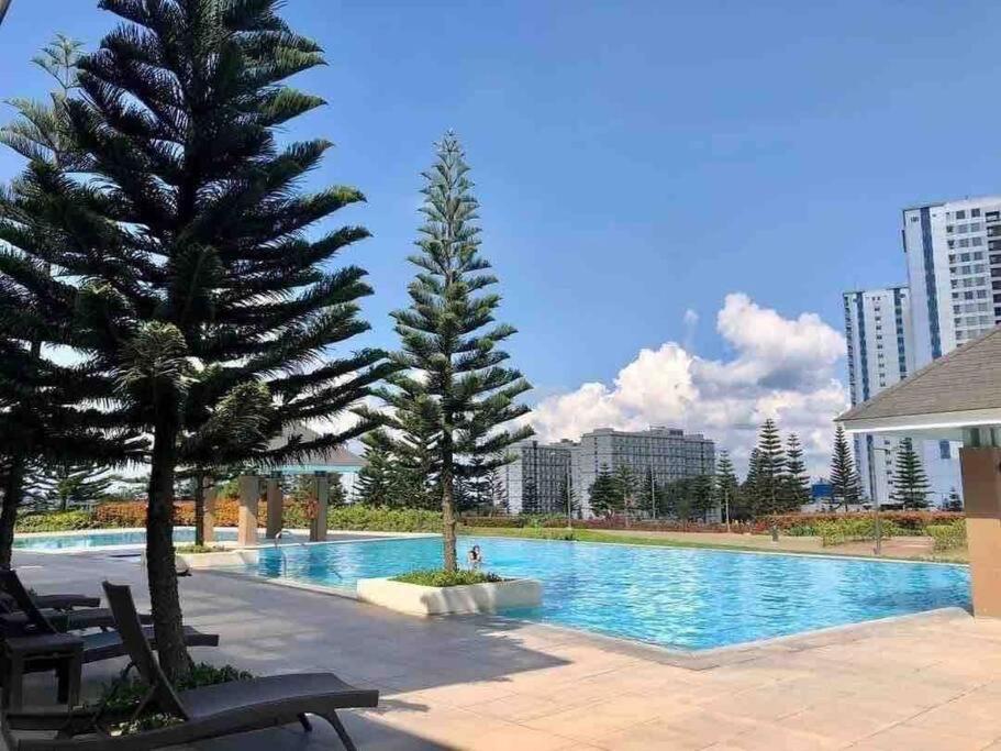 een zwembad met twee bomen naast een gebouw bij New Cozy Staycation in Tagaytay in Tagaytay