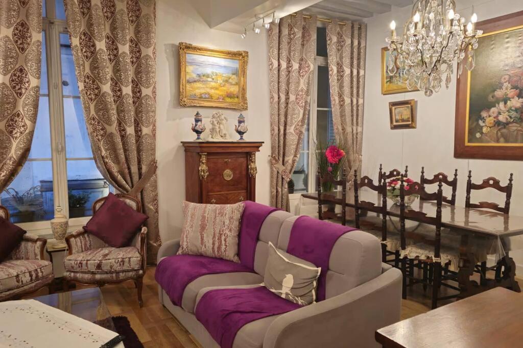 un salon avec un canapé violet et une table dans l'établissement Very Chic Flat Paris VI, à Paris