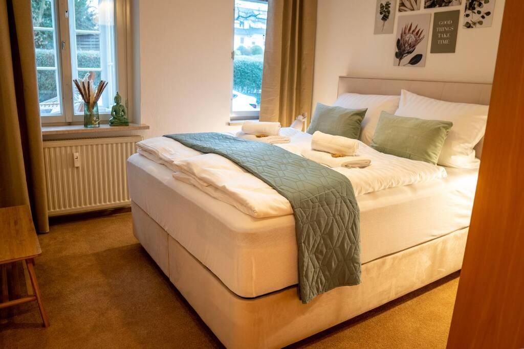 Cette chambre comprend un grand lit blanc et une fenêtre. dans l'établissement VILLA I 100m Kurpark I Wintergarten Boxspringbett I NETFLIX, à Bad Salzuflen