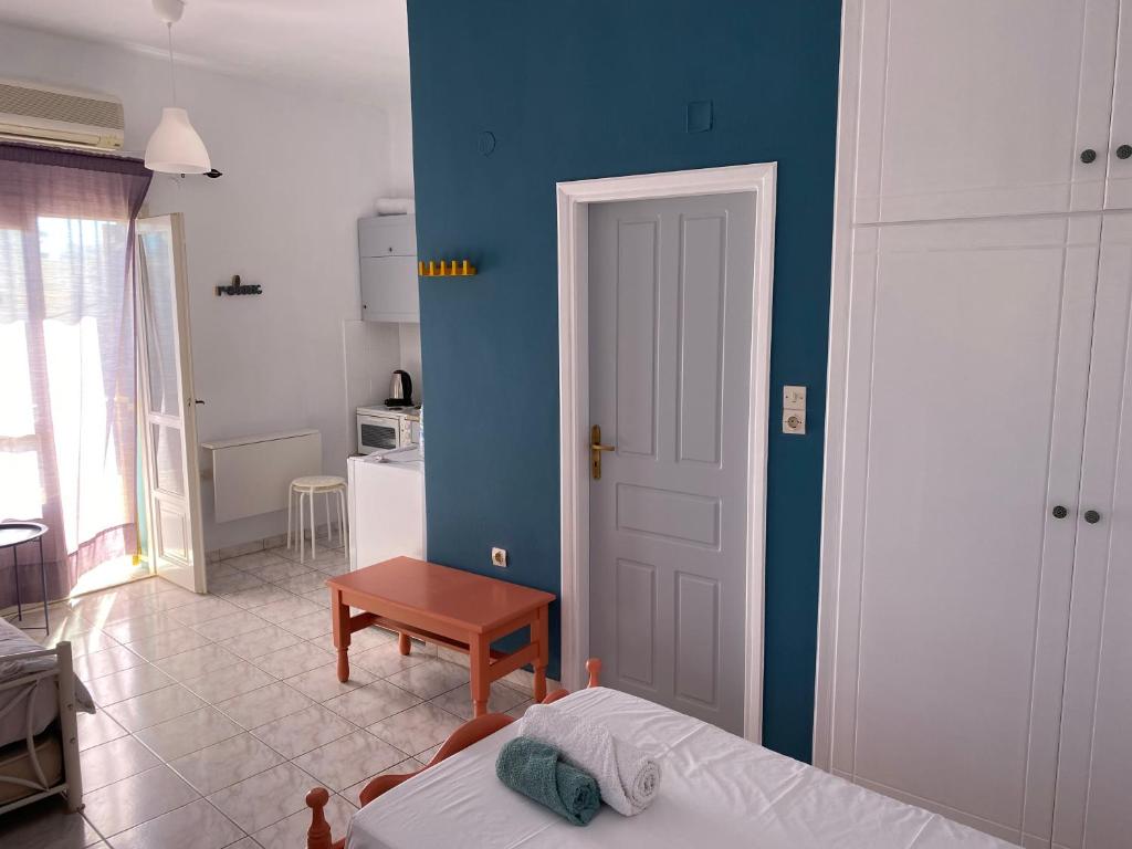Zimmer mit einem Bett und einer blauen Wand in der Unterkunft Mitato Studios in Myrtos
