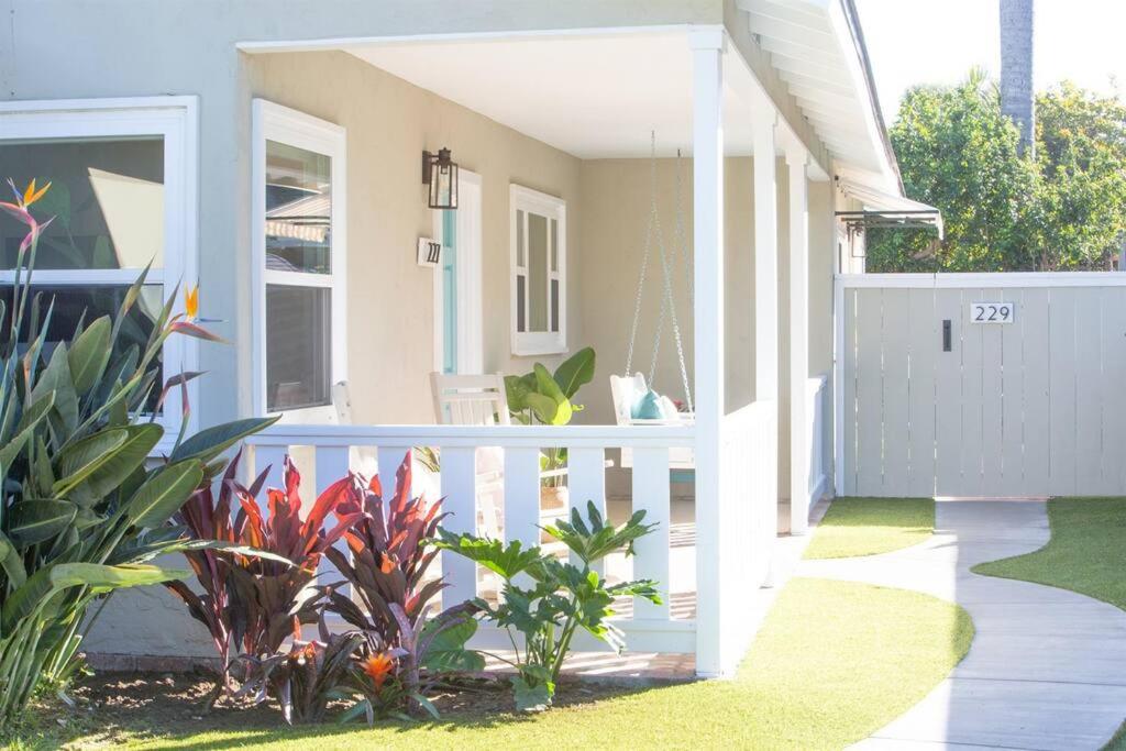ein Haus mit einem weißen Zaun und einigen Pflanzen in der Unterkunft Live the Beach Life in a Quaint Shell Cottage in Del Mar