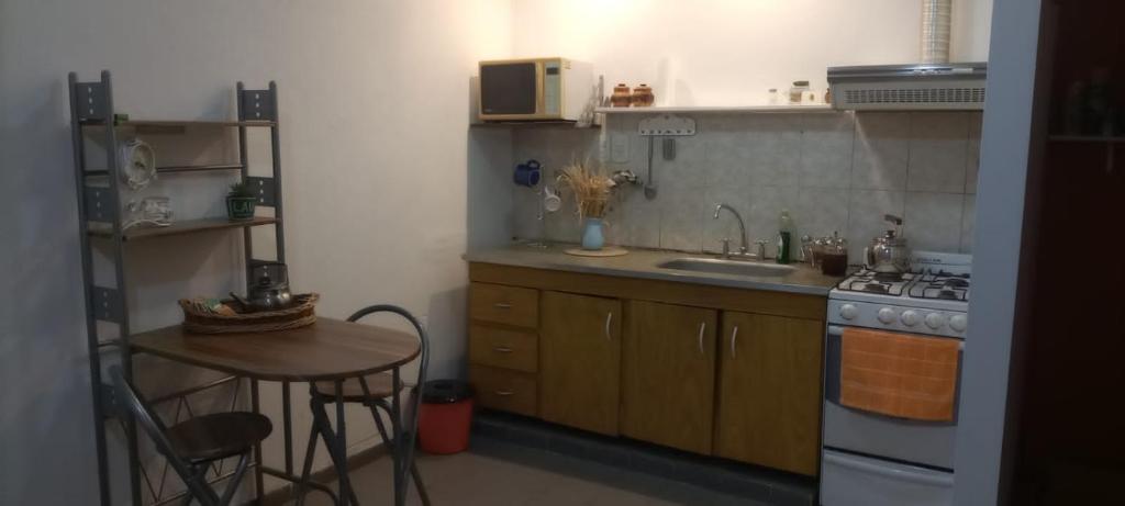 a kitchen with a stove and a sink and a table at Departamento MDP 4personas max in Mar del Plata