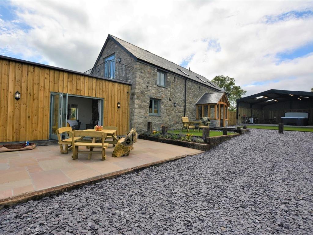 a barn conversion with a patio and a house at 4 Bed in Denbigh 76475 in Llannefydd